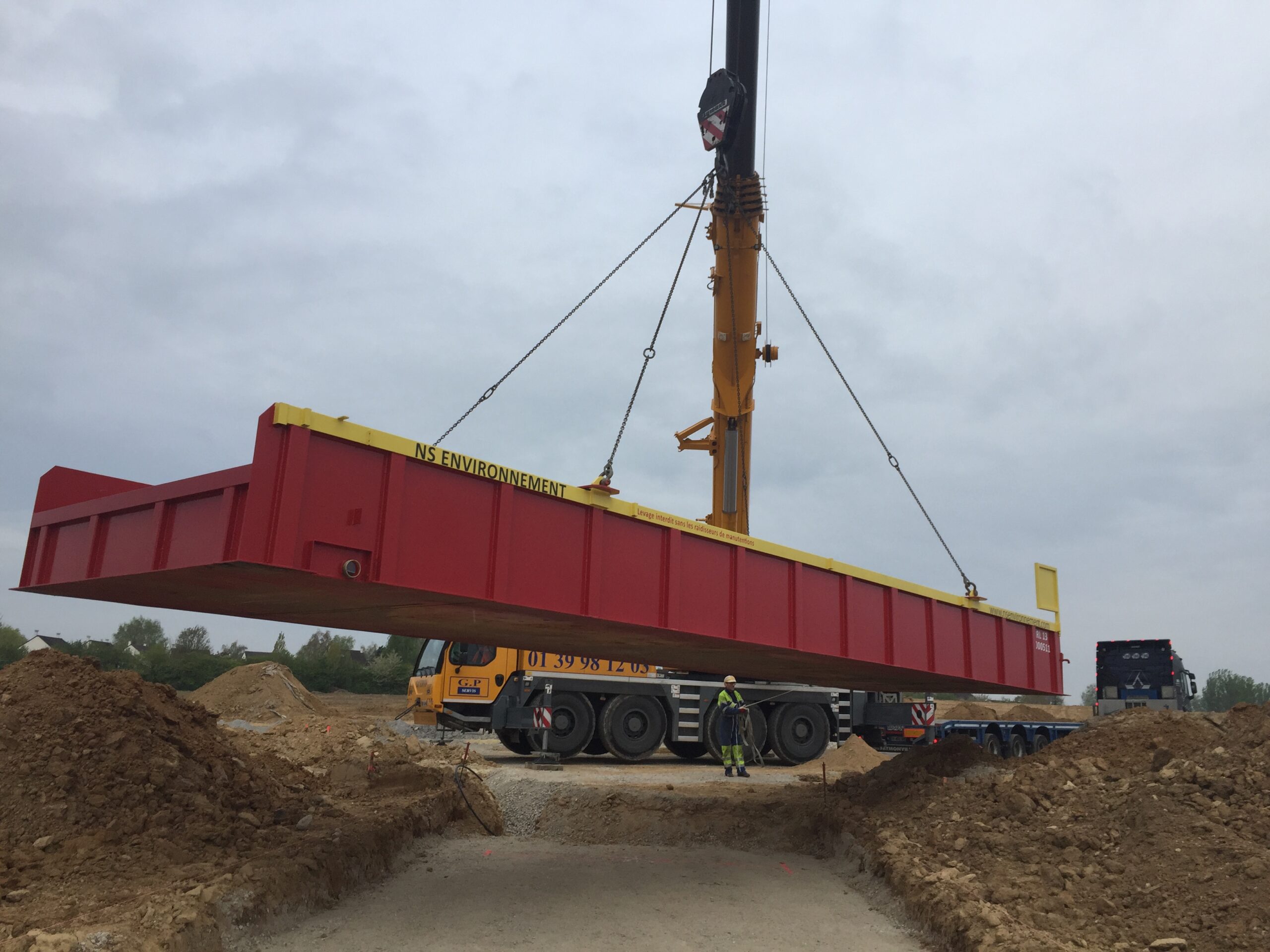 Installation d'un raton-laveur au moyen d'une grue de levage.